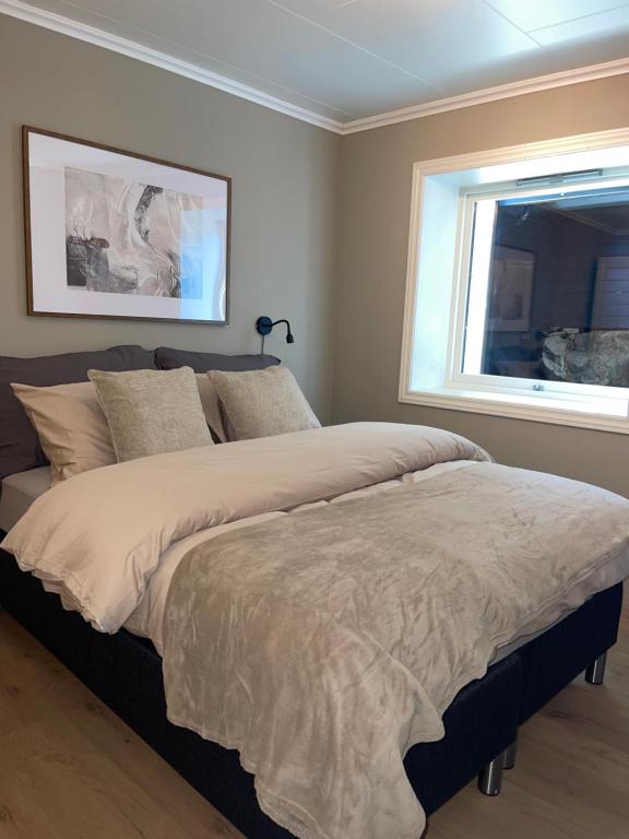 a bedroom with a large bed with a window at 2 leiligheter med panoramautsikt in Bergen