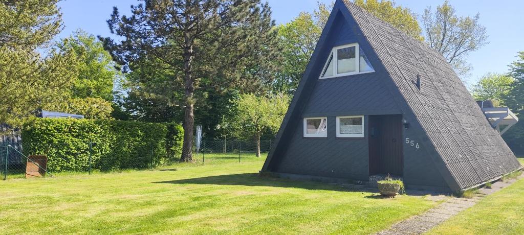 ein blaues Haus mit einem Walmdach auf einem Hof in der Unterkunft Ferienhaus Ostseeküste in Damp
