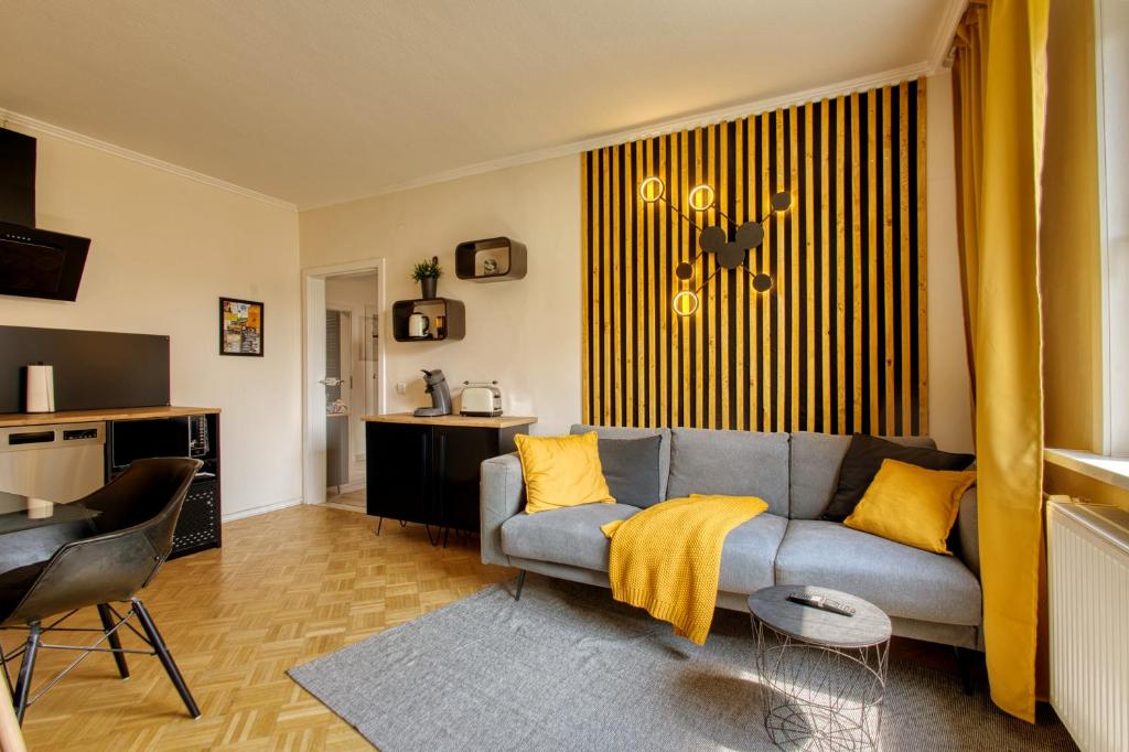 a living room with a gray couch and yellow pillows at Ruhige Wohnung zwischen Harz & Göttingen - 4 Personen in Wulften