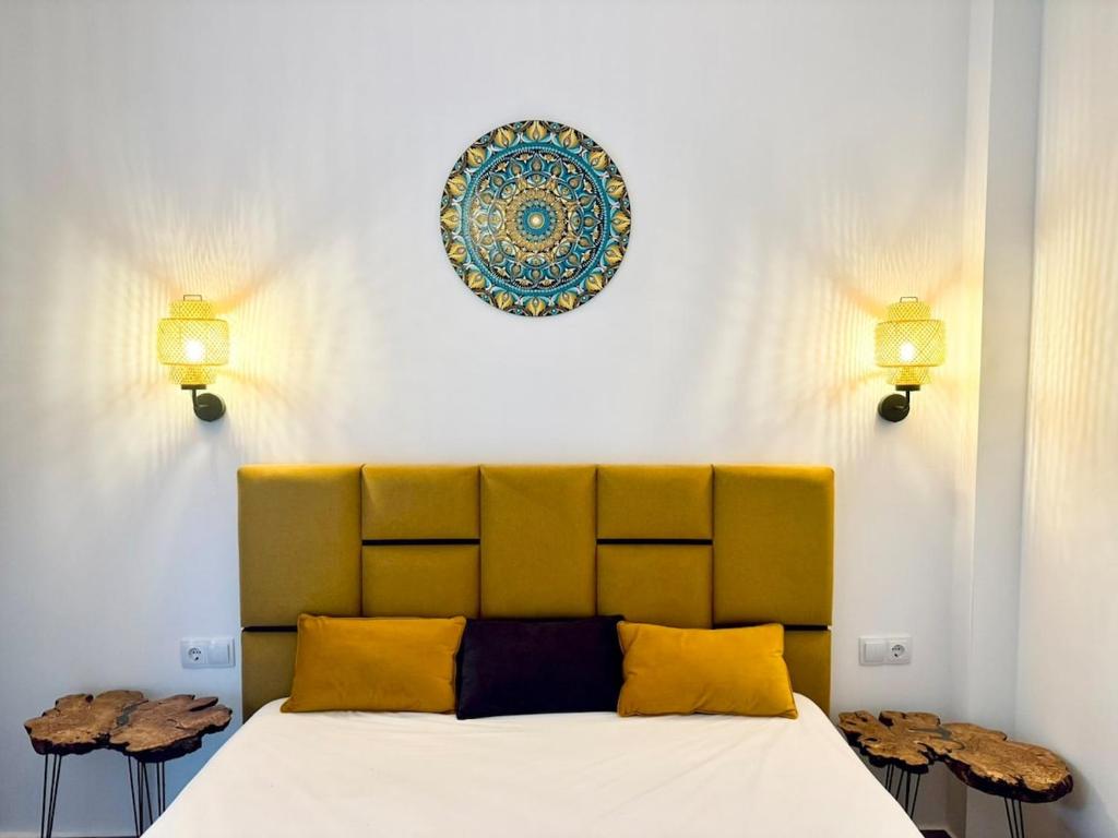 a bedroom with a bed with yellow pillows and a plate on the wall at Apartment Chrisi in Skala Potamias