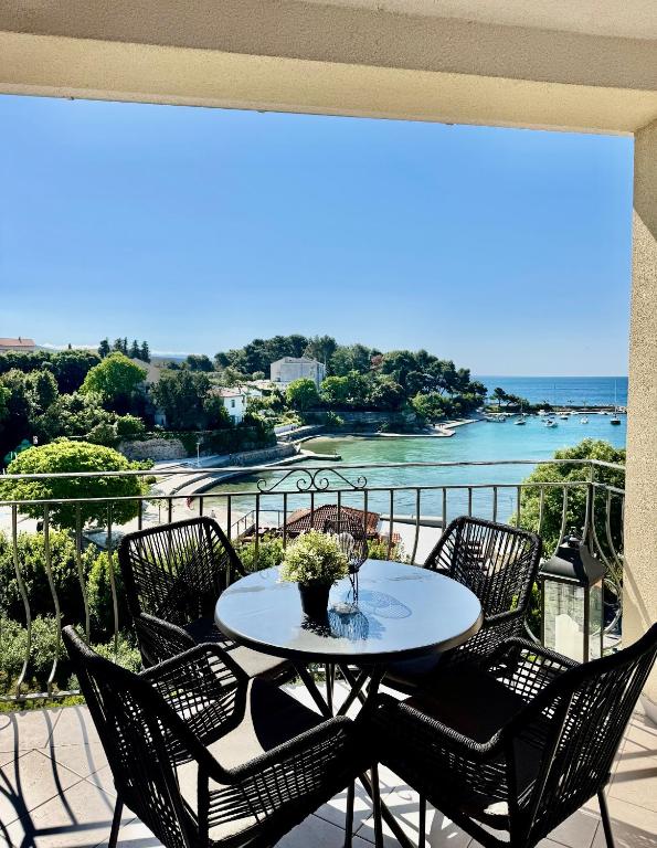 a table on a balcony with a view of the ocean at Apartment Jelka 1 in Krk