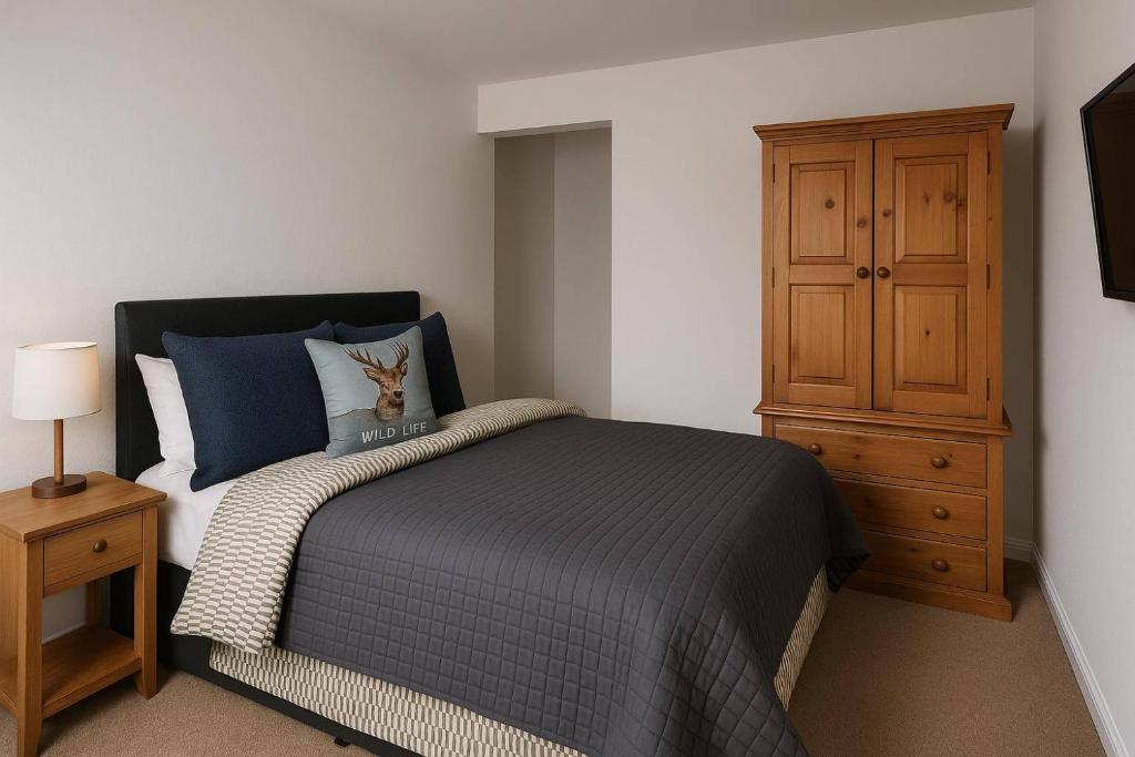 una camera da letto con un letto e un armadio in legno di Two bedroom cottage in Lumsden - Contractors a Huntly