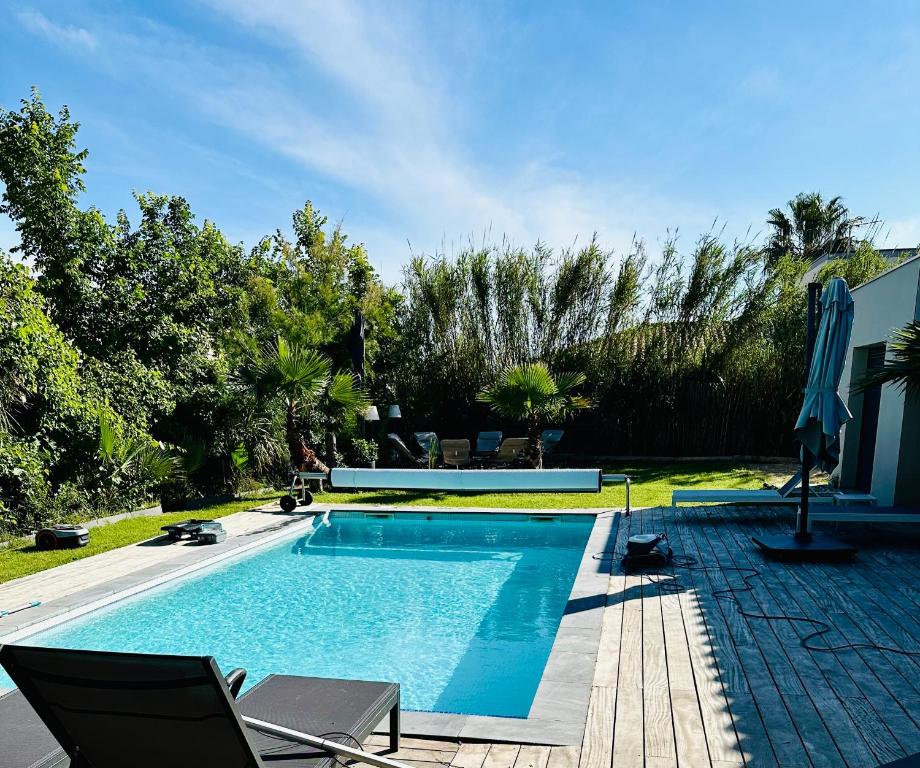 - une piscine dans une cour avec des chaises dans l'établissement Villa architecte ecume 400m plage, au Cap d'Agde