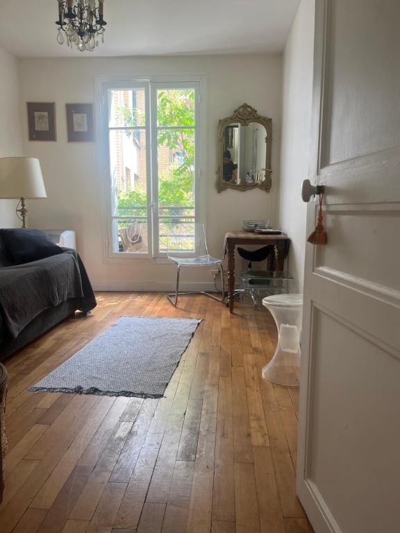 un salon avec un lit et une fenêtre dans l'établissement Charming apartment Eiffel Tour/Invalides, à Paris