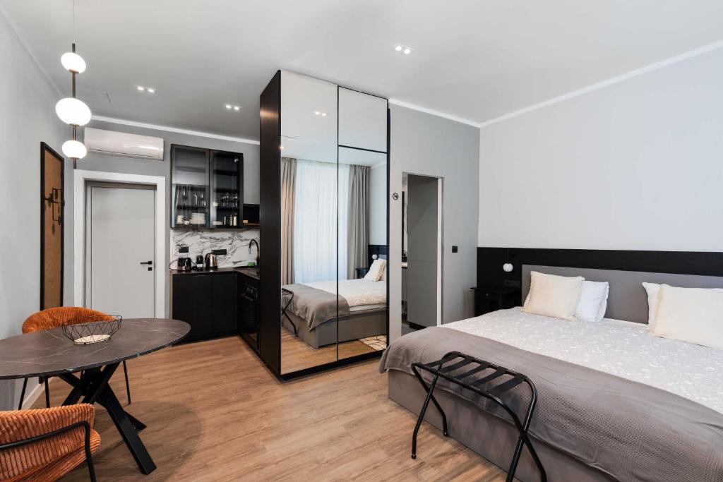 a bedroom with a bed and a table and a room at Sir John's Apartments in Rijeka