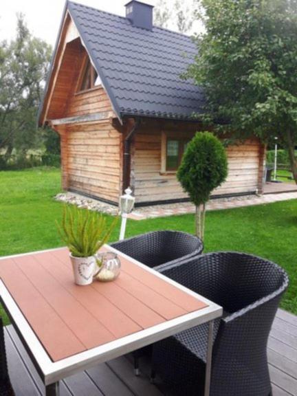 a table and chairs on a deck with a house at Domki z bali Polanica-Zdrój in Polanica-Zdrój