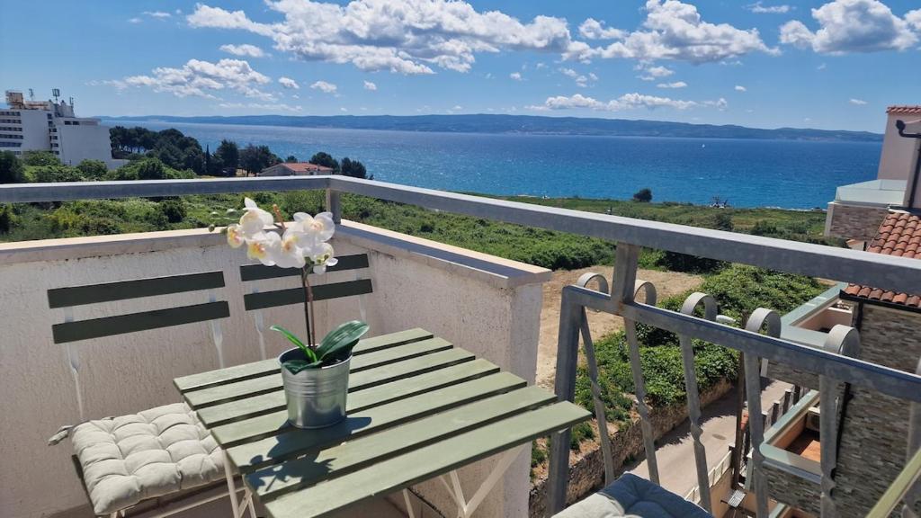 a wooden table with a flower on a balcony at Rooftop sea view apartment in Split