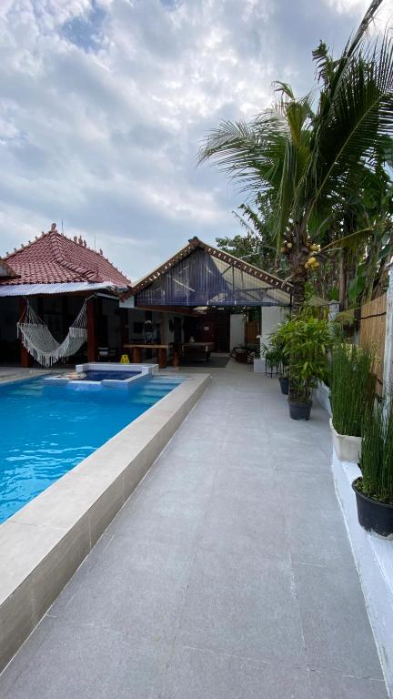 a resort with a swimming pool and palm trees at Villa Padi Pakem in Pakem