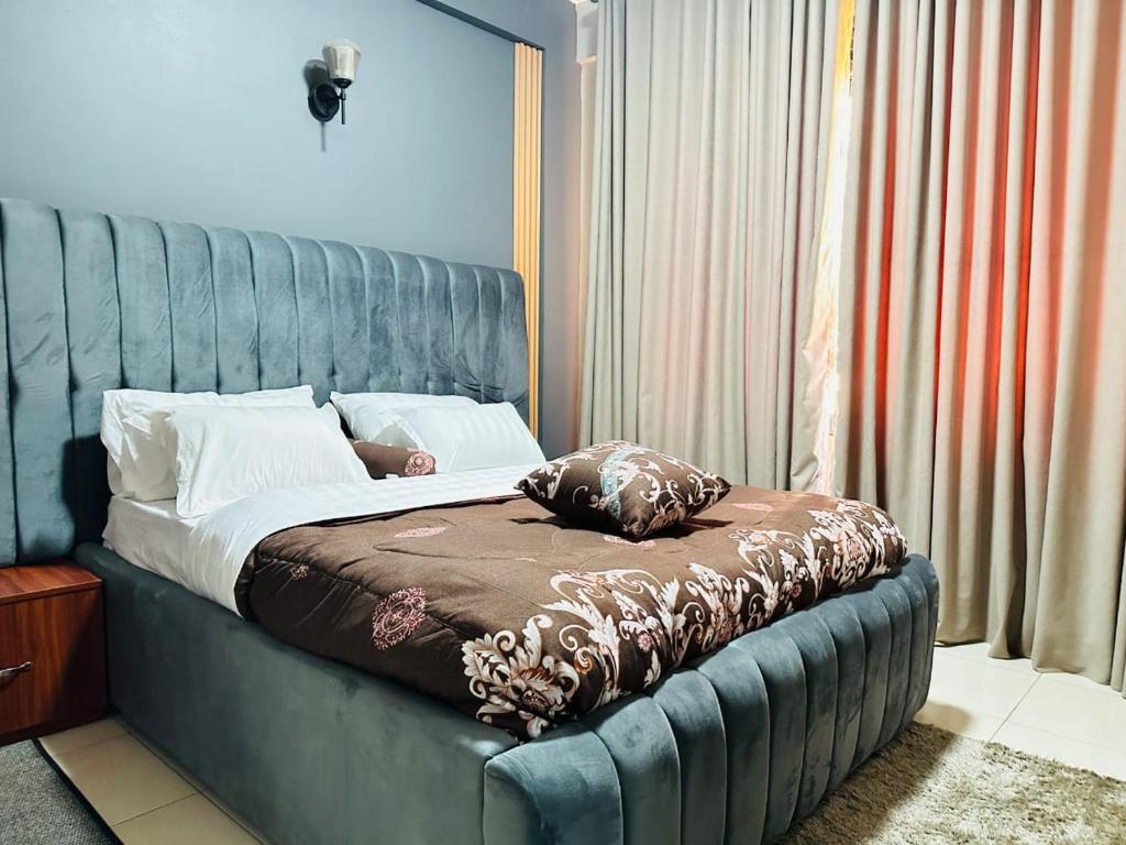 a bed with a blue headboard in a room at Silver Homes ug in Kampala