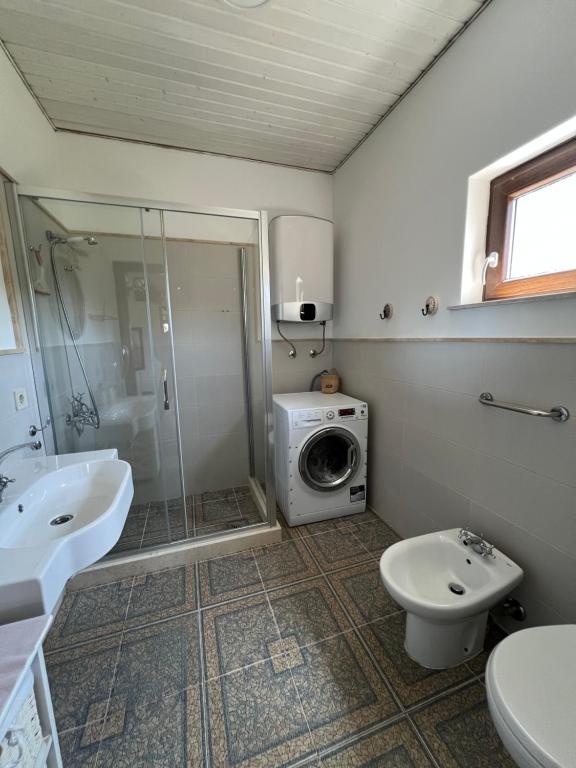 a bathroom with a shower sink and a washing machine at Villa SHU in Krimovice