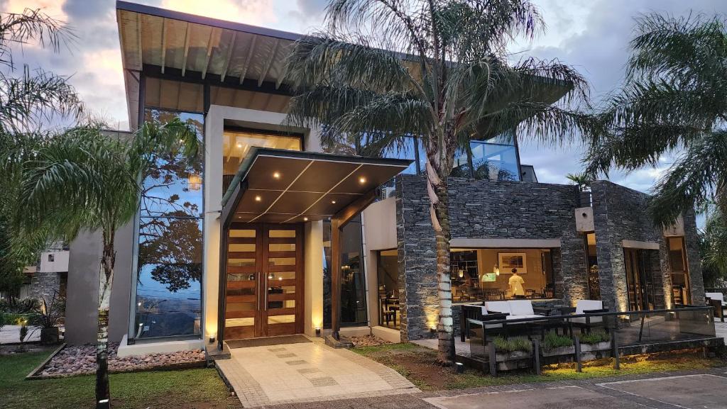 a house with glass doors and a palm tree at Altos De Merlo Suites in Merlo