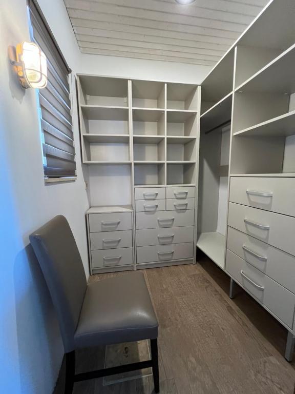 a walk in closet with a chair and shelves at Villa SHU in Krimovice