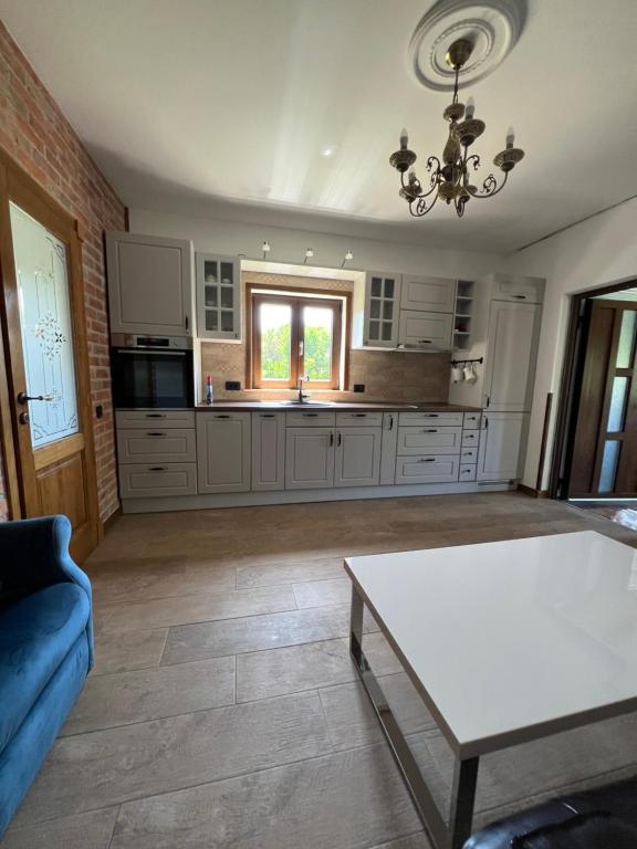 a large kitchen with white cabinets and a table at Villa SHU in Krimovice