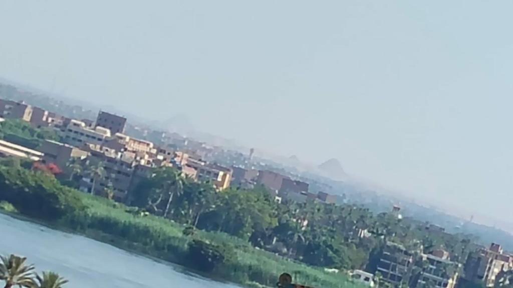 un pueblo en una colina al lado de un río en Luxurious panoramic Nile view room, en El Cairo