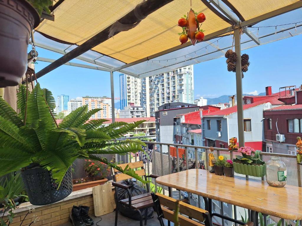 un patio con tavolo e piante su un balcone di Chase Dream Hostel追梦空间 a Batumi
