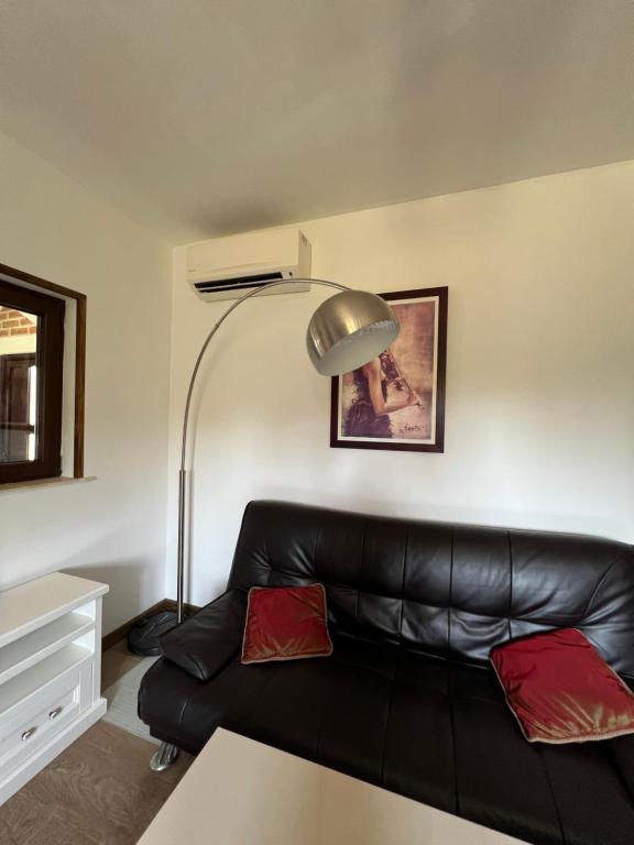 a black leather couch in a living room with a lamp at Villa SHU in Krimovice