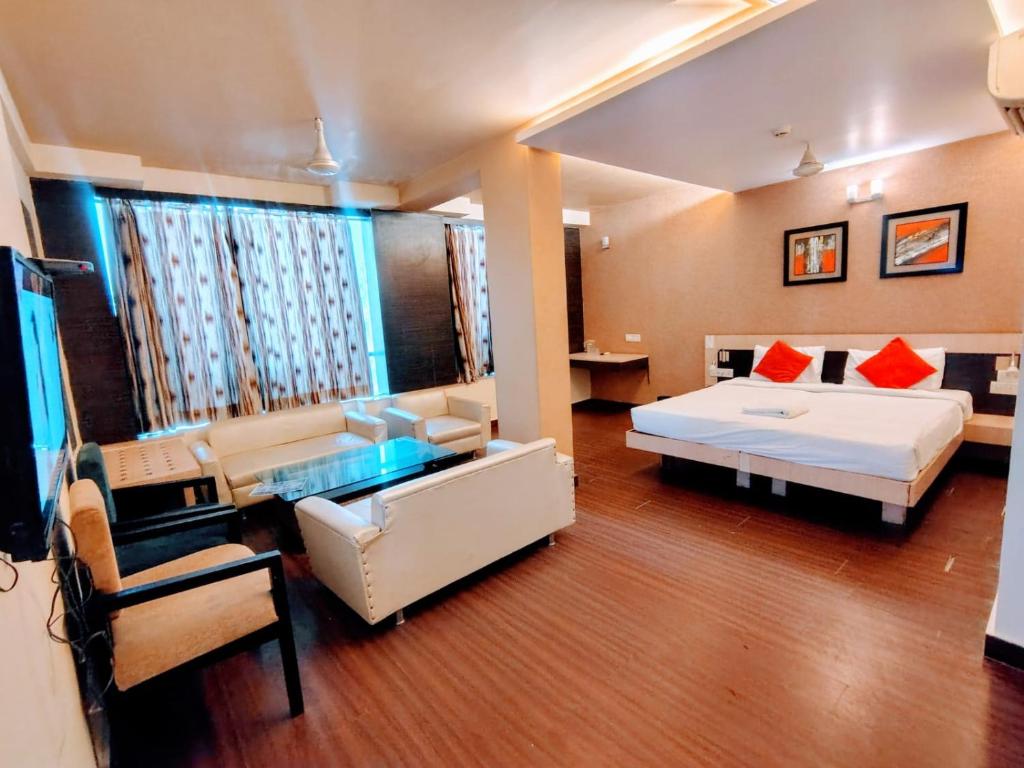 a hotel room with a bed and a living room at Hotel Apex Intercontinental in Jaipur
