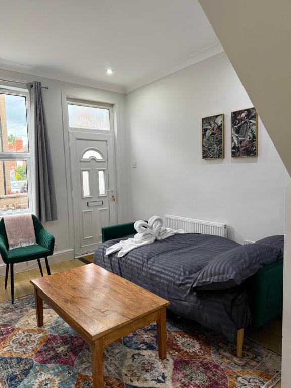 Un dormitorio con una cama y una mesa de café. en Cosy Lincoln Home Sleeps 6 with Parking, en Boultham