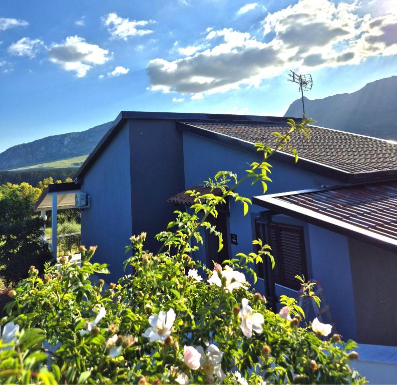 a blue house with mountains in the background at Chalet Ponte Paradiso Suite & SPA in Santa Cristina Gela