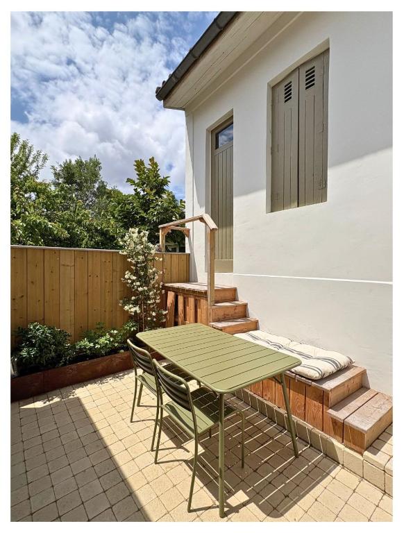 une table verte et une chaise sur une terrasse dans l'établissement Chouk House - Idéal Famille avec Terrasse, à Bordeaux