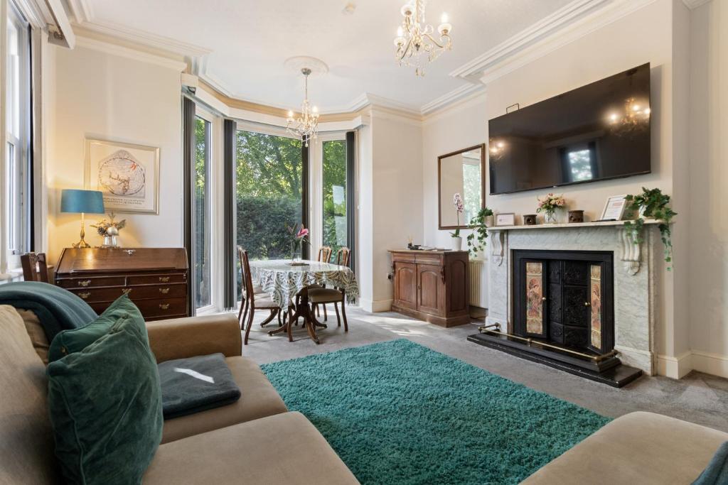 a living room with a couch and a fireplace at Elegant Malvhina Retreat on the Malvern Hills in Great Malvern