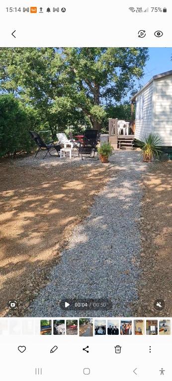 une photo d'une cour avec un banc et un bâtiment dans l'établissement charmant mobil home de patricia et bruno, à Sainte-Croix-de-Verdon