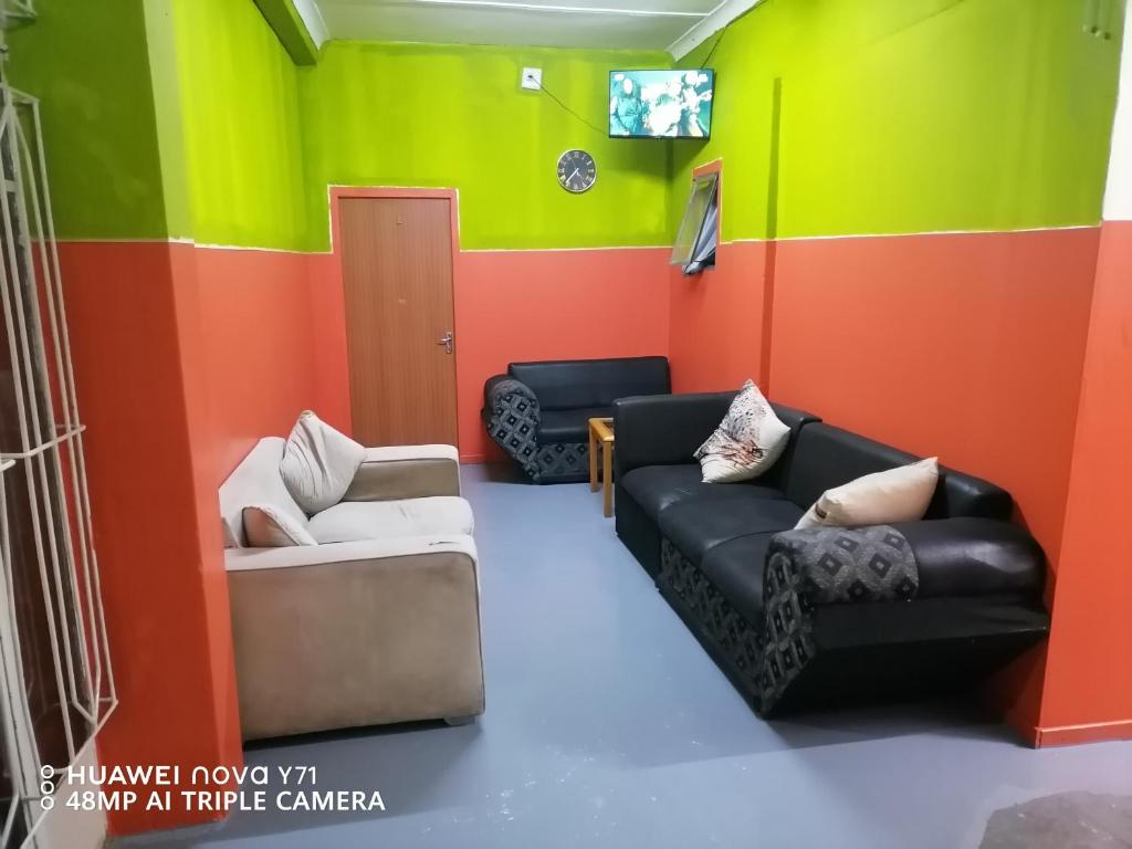 a living room with colorful walls and couches at Sunset Executive Lodge in Boksburg