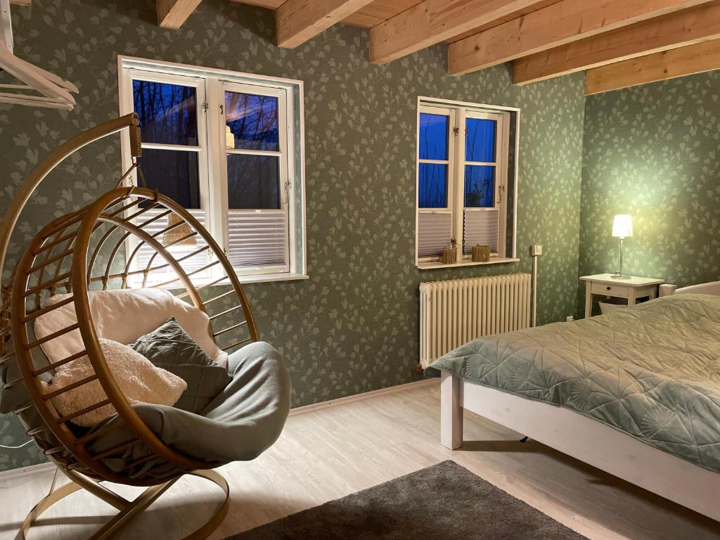 a bedroom with a bed and a chair and windows at Ferienhaus Emma in Langelsheim
