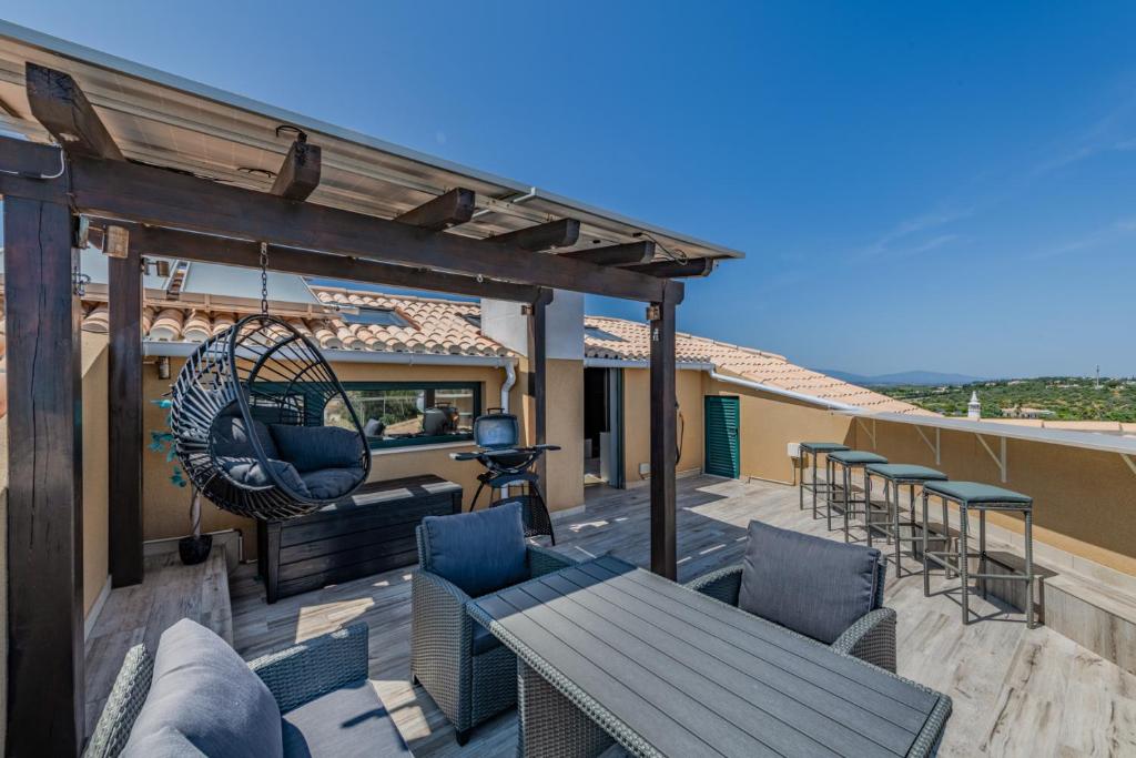 a patio with a hammock and a table and chairs at Bela Vista Exclusive Private Villa in Praia da Luz in Luz