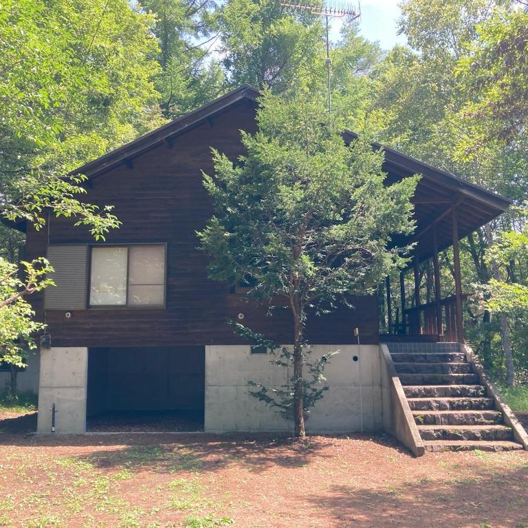 a house with a tree in front of it at SAKURA BBQ home theater etc in Tsumagoi