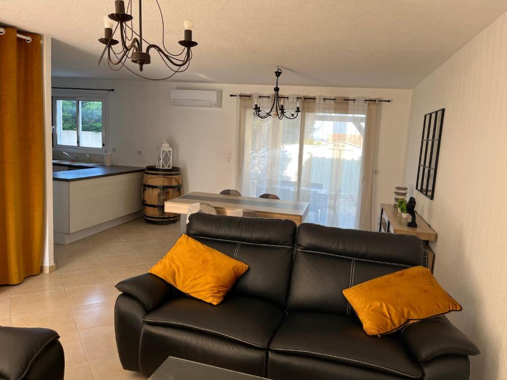 un salon avec un canapé et une cuisine dans l'établissement Charmante VILLA 95 M2, à Vinassan