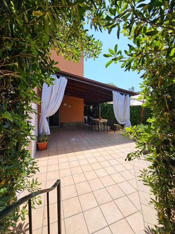 a patio with white drapes on a house at Residenza Ponente in Stintino