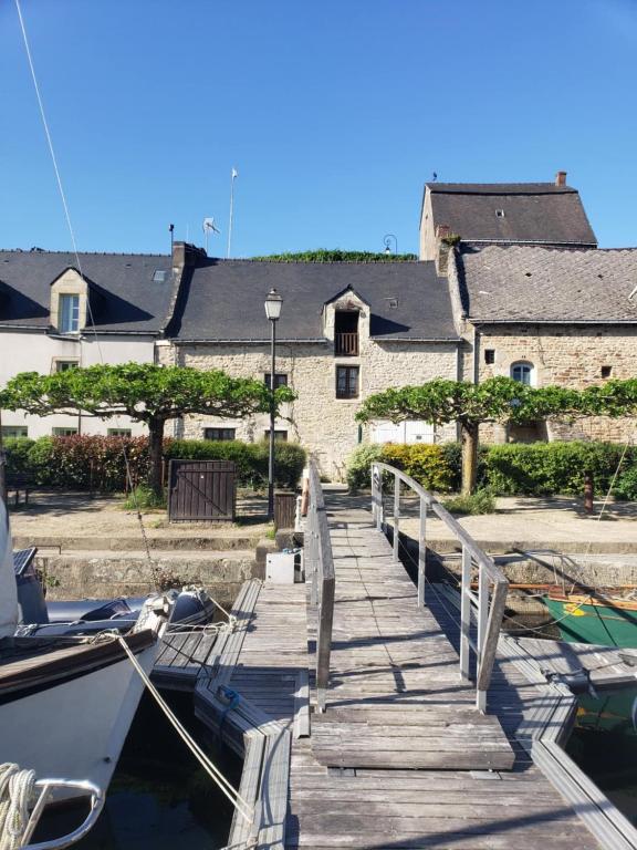 un quai avec un bateau garé à côté d'un bâtiment dans l'établissement Appartement la Roche Bernard, à La Roche-Bernard