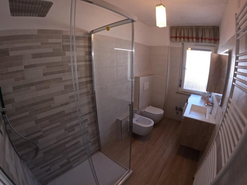 łazienka z prysznicem, toaletą i umywalką w obiekcie casa Daria w mieście Predazzo