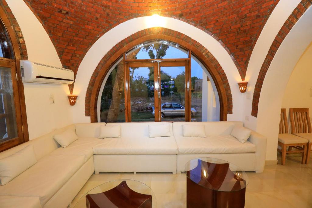 a living room with a white couch and a window at Desert Rose apartment's in Luxor