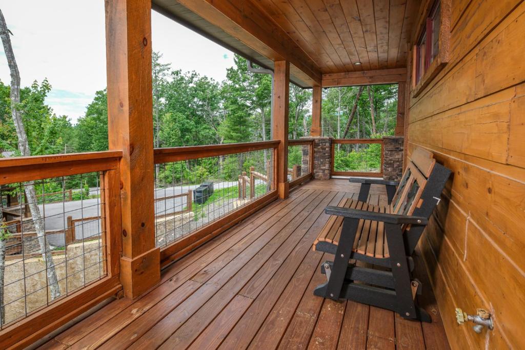 a porch of a cabin with a bench on it at Abundantly Blessed in Sevierville