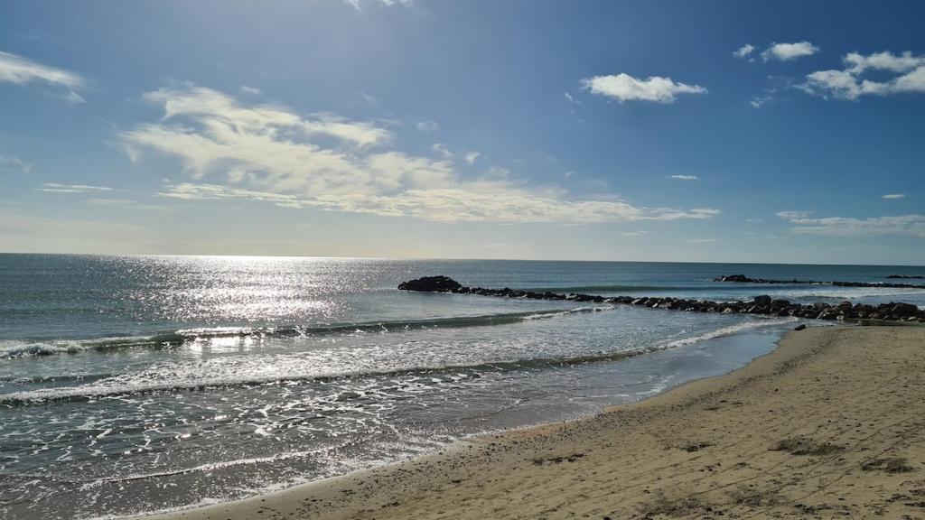une plage avec un groupe de rochers dans l'eau dans l'établissement T2 lumineux plage et piscine, à Frontignan
