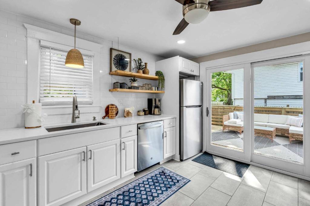 eine Küche mit weißen Schränken und einer Glasschiebetür in der Unterkunft Bungalow Blue in Bradley Park in Neptune City