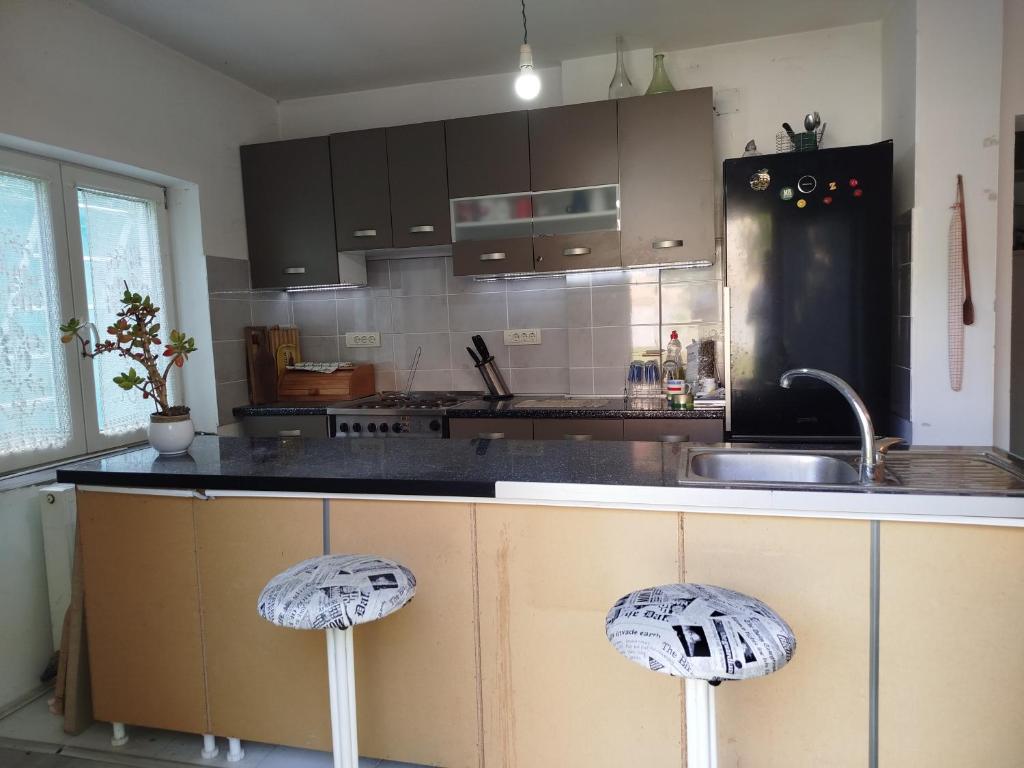 a kitchen with a counter top with two stools at Guesthouse 2207 in Sremski Karlovci