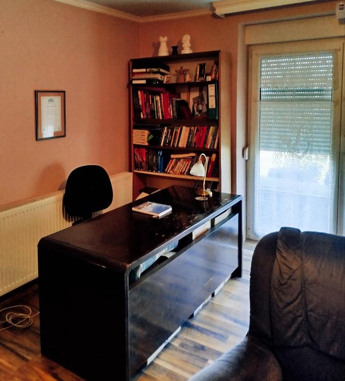 a desk in a living room with a book shelf at Guesthouse 2207 in Sremski Karlovci