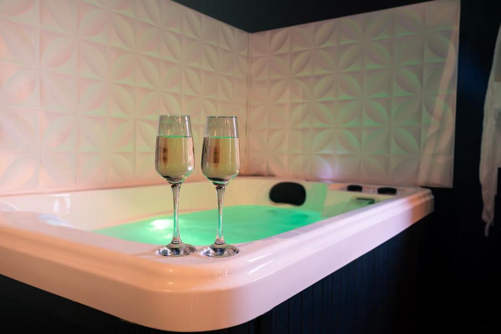 - deux verres à champagne assis dans une baignoire dans l'établissement TheRubyLodge, à Ourville-en-Caux