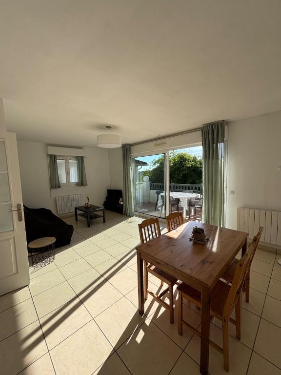 un salon avec une table et des chaises en bois dans l'établissement Maison a Socoa, à Urrugne