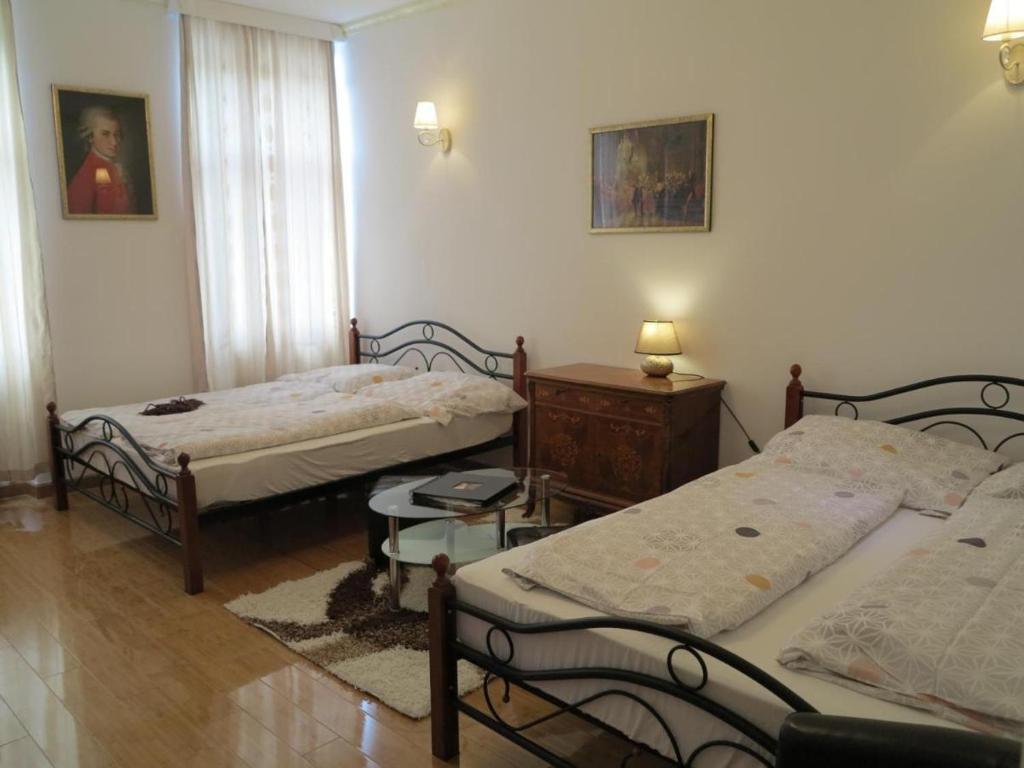 a bedroom with two beds and a table and a window at Inter20 in Vienna