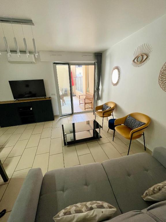 un salon avec un canapé et une télévision dans l'établissement Jolie 3 pièces avec terrasse au vieux port, à 2 pas des plages et du palais., à Cannes