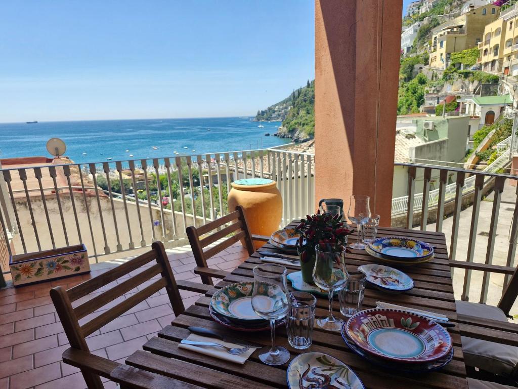 a wooden table with a view of the ocean at Casa Delia, apartment close the sea in Vietri sul Mare