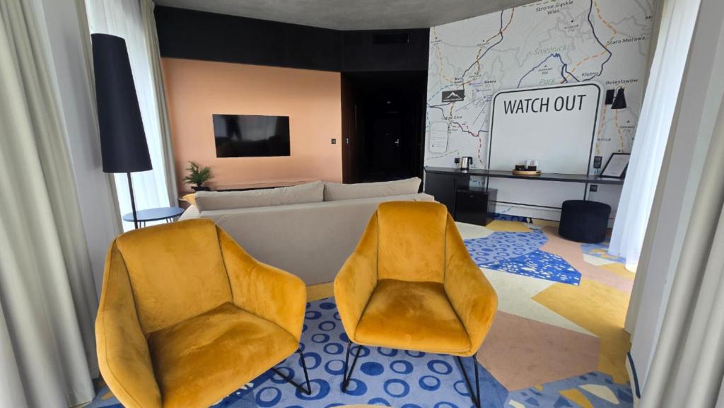 - un salon avec deux chaises jaunes et un canapé dans l'établissement Apartament - White Pearl - Biała Perła - Czarna Góra, à Sienna