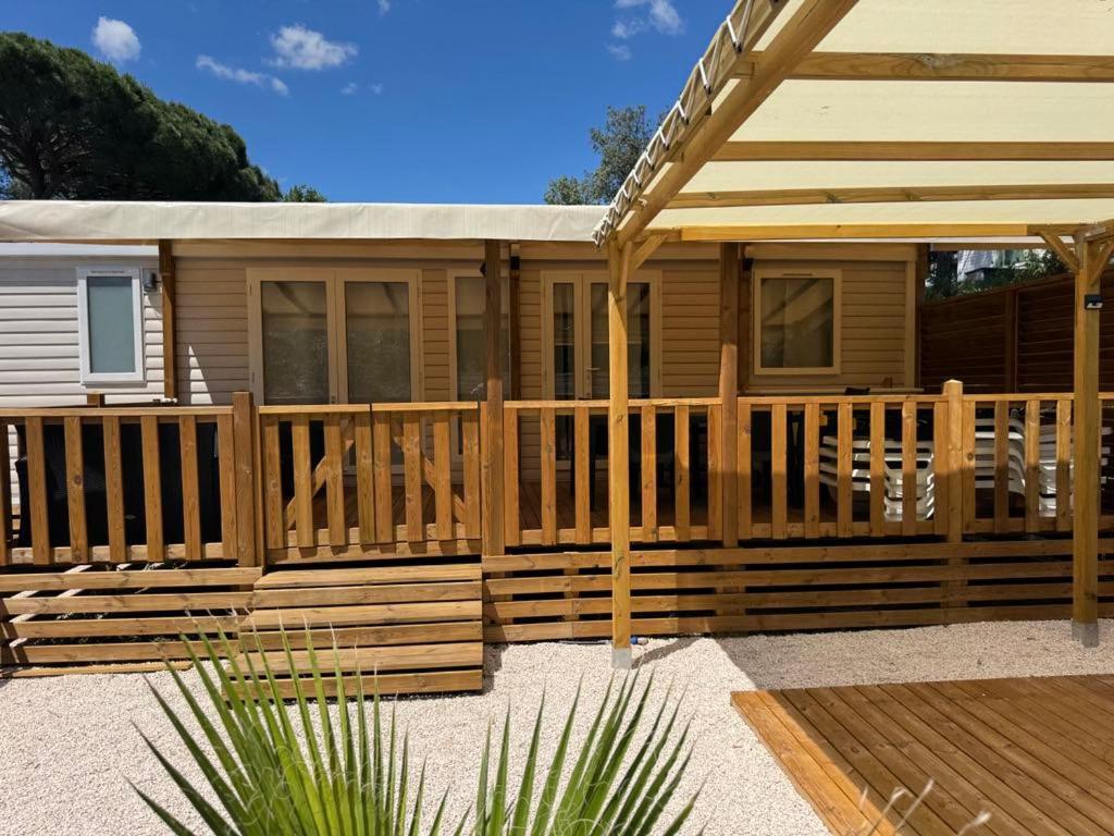 Ce chalet en bois dispose d'une véranda et d'une terrasse. dans l'établissement Mobilhome Gamme résidentielle, au Muy