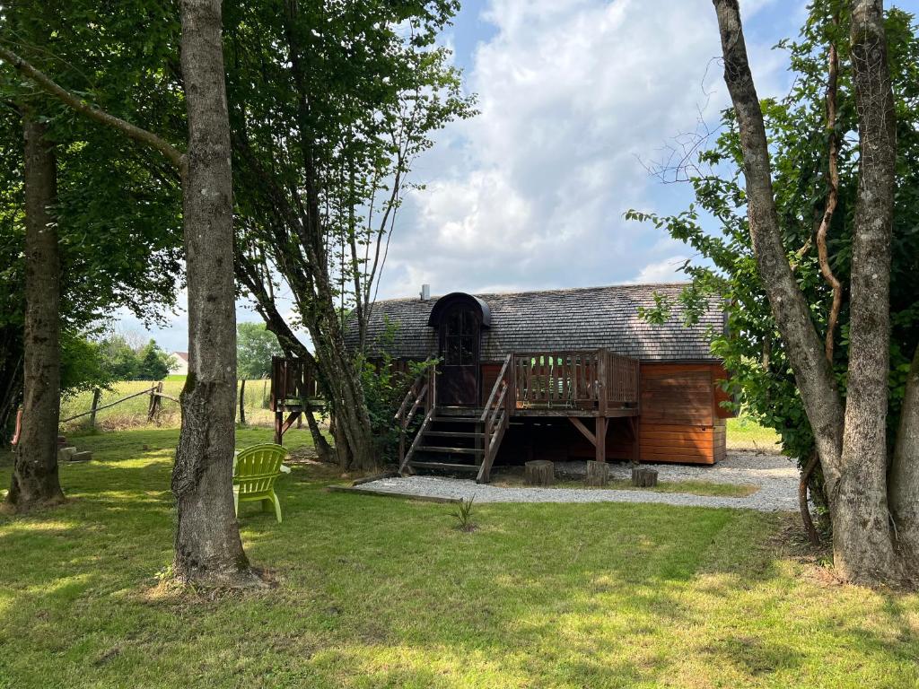 a log cabin with a deck in a yard with trees at barrique viticole in Le Tartre