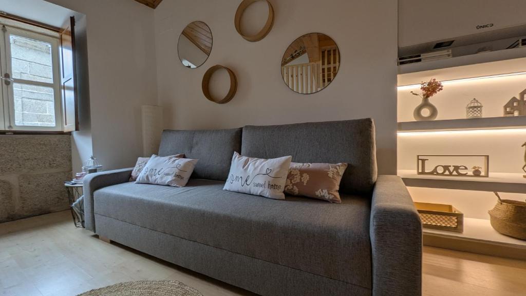 a living room with a couch and some mirrors at Cantiño 39 in Lugo