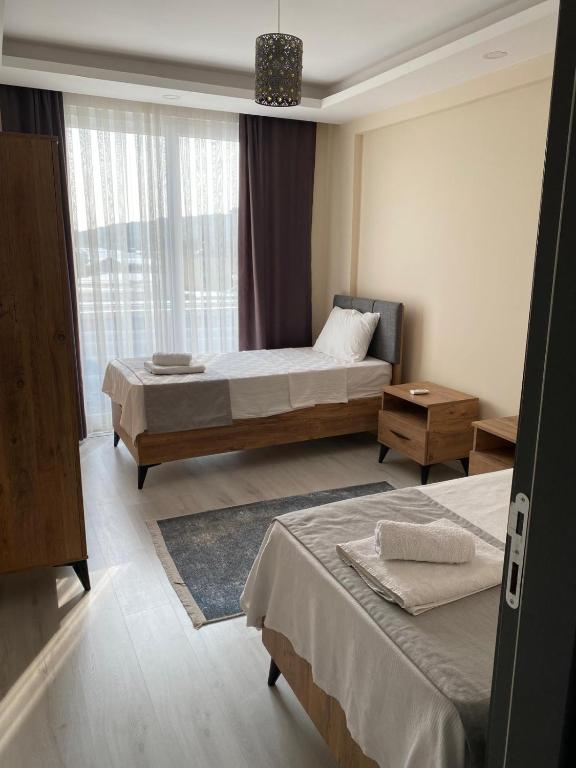 a hotel room with two beds and a window at Atlas Apart Demre in Zumrutkaya